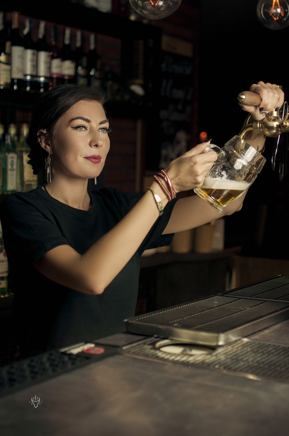 Praca barmanki przy przygotowaniu drinka.