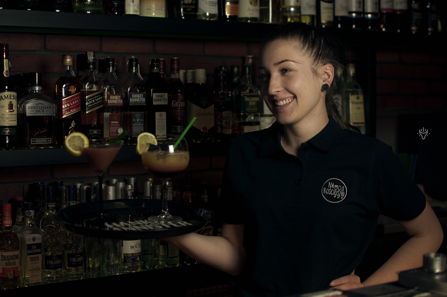 Pracownica restauracji podaje tacę z napojami.