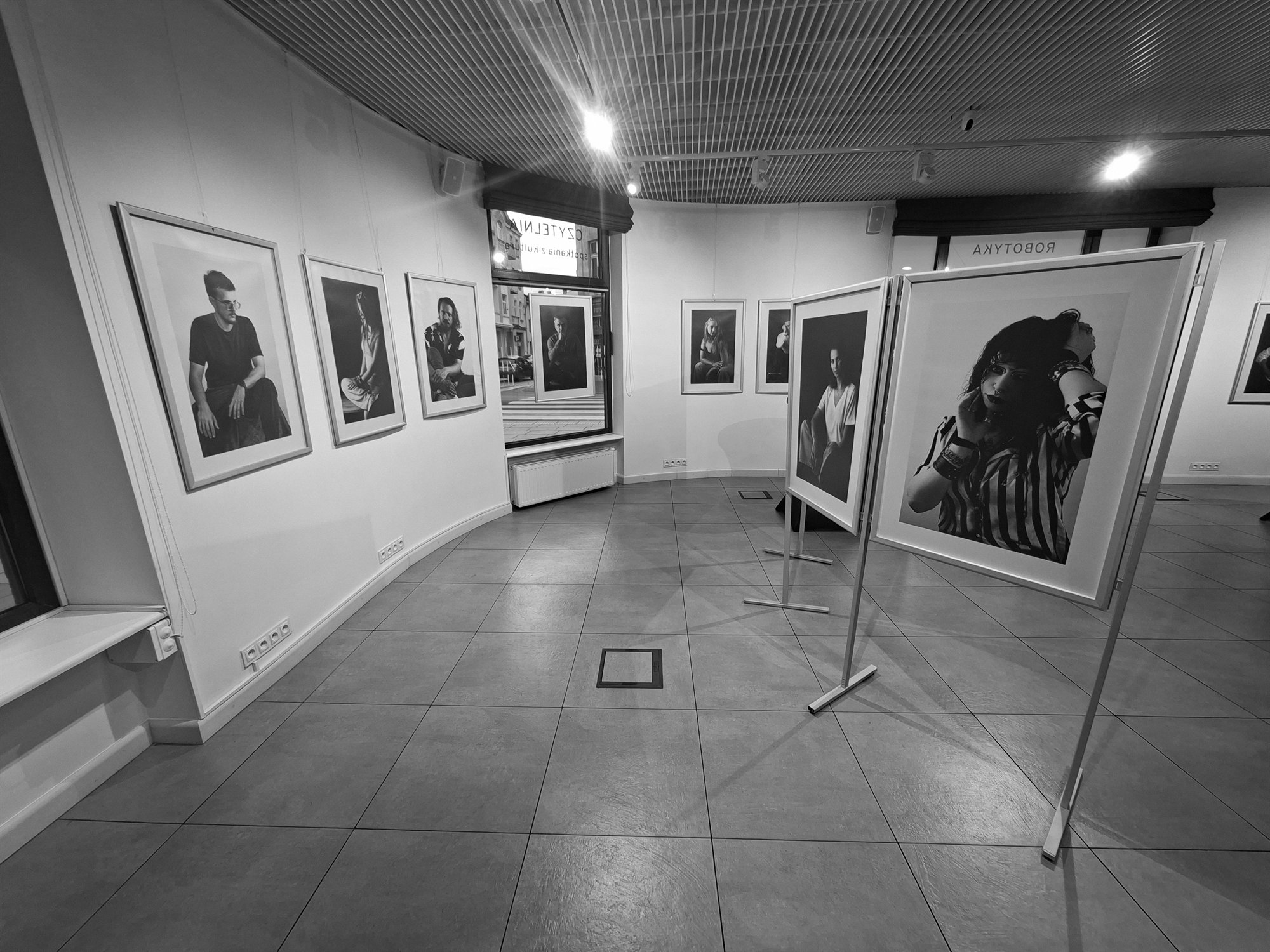 Wnętrze wystawy z wolnostojącymi fotografiami.